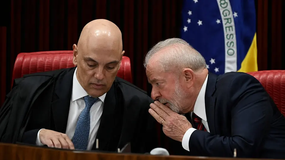 Porträtfotos von STF-Richter Alexandre de Moraes und Präsident Luiz Inácio Lula da Silva nebeneinander vor der brasilianischen Flagge