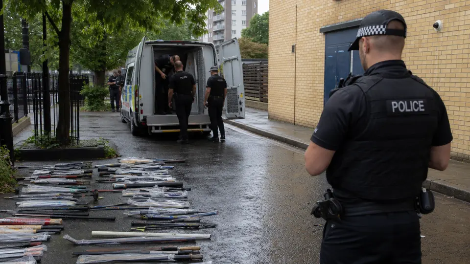 Crowds at Notting Hill Carnival with a heavy police presence lining the street