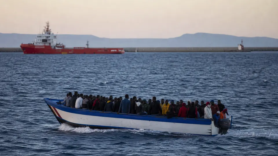 Spanish coastguard vessel intercepting a small inflatable boat carrying migrants in the western Mediterranean Sea