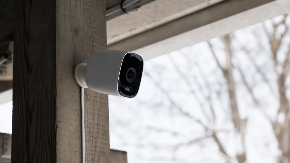 The Shelly Camera mounted on a wall with a USB-C cable routed for power, shown in a domestic setting.