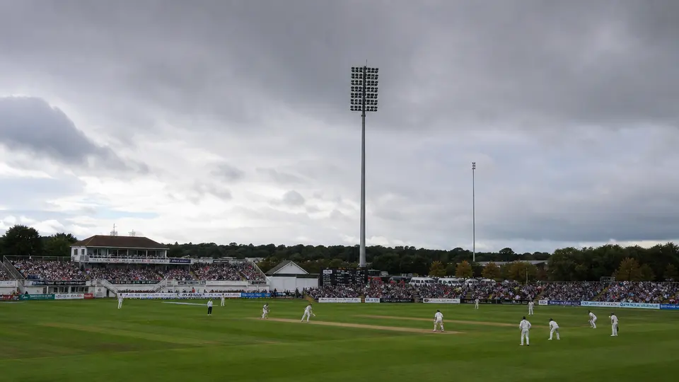 County cricket action at a ground in England during a September championship match, players in whites on the field